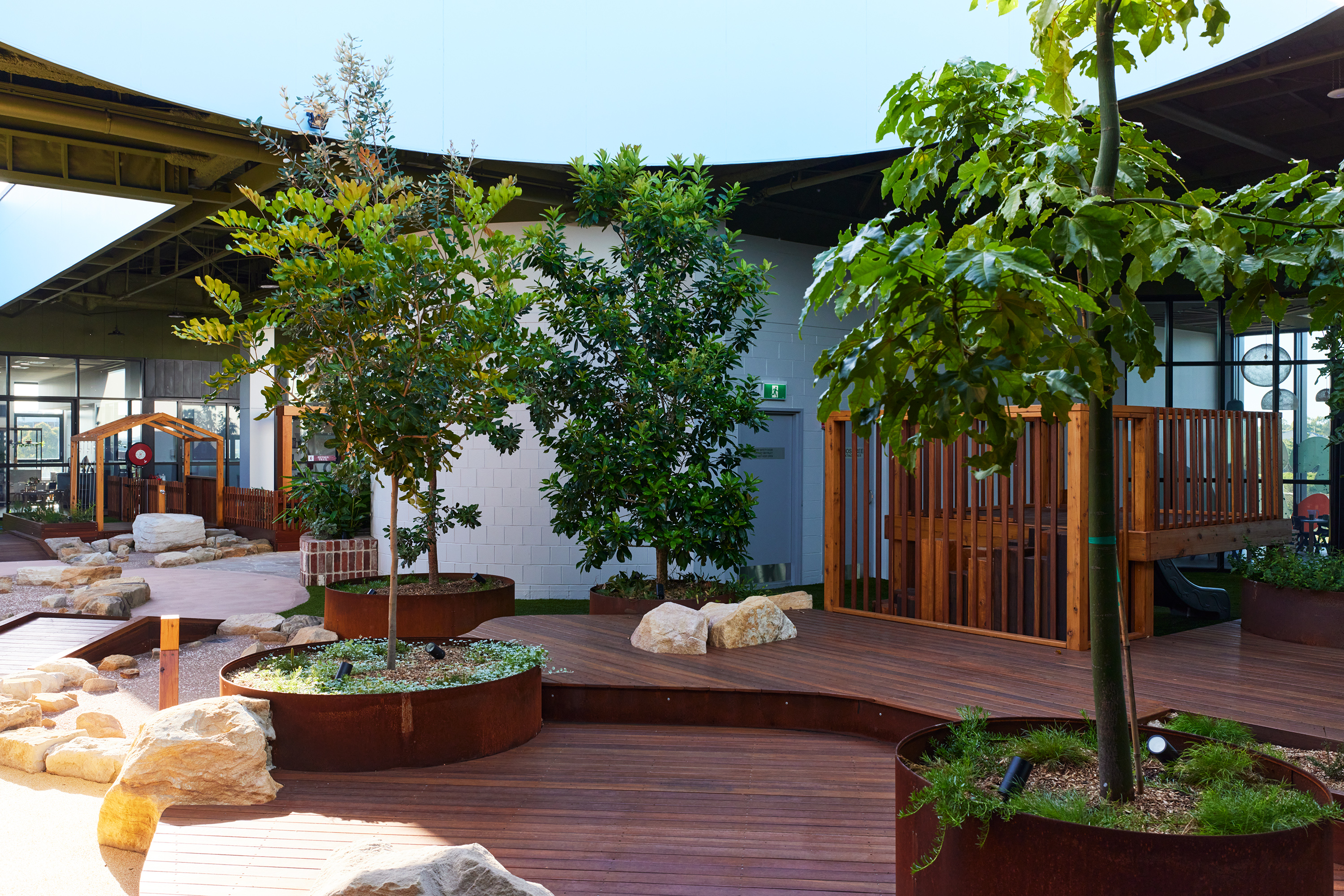 Timber decking and native garden beds in rooftop play environment
