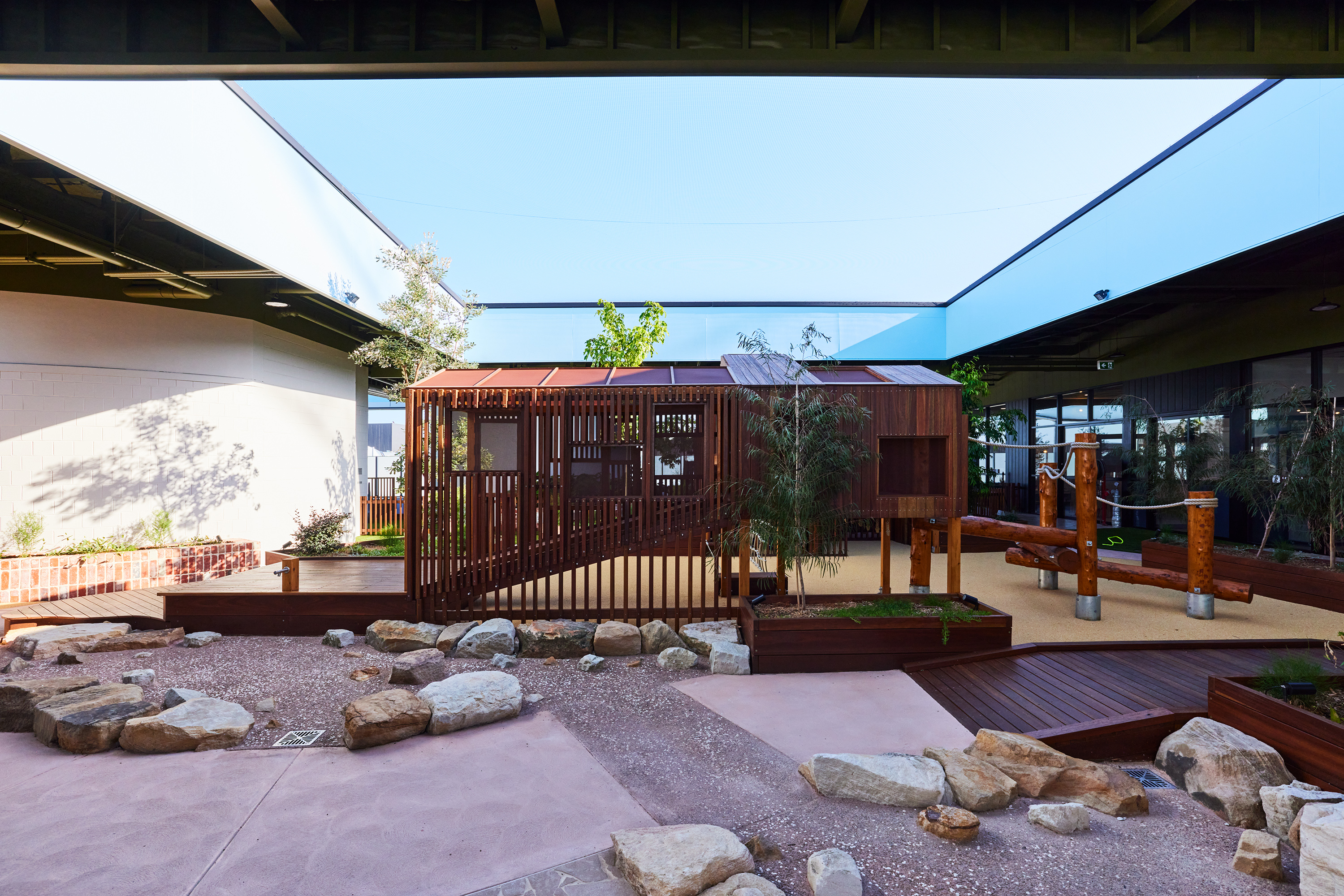Natural timber walkway connecting play zones with garden integration