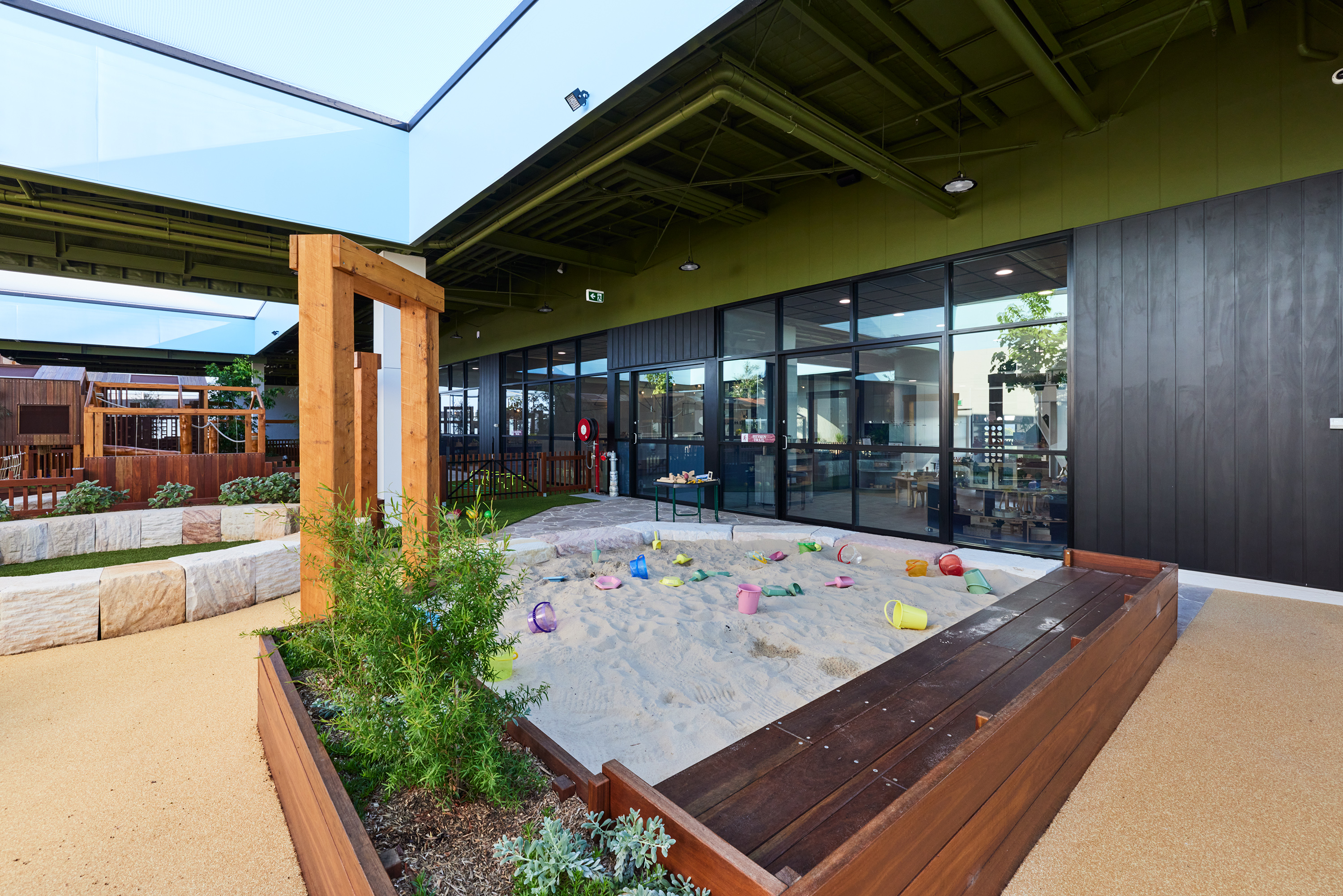 Children's play zone with natural stone seating and planted areas