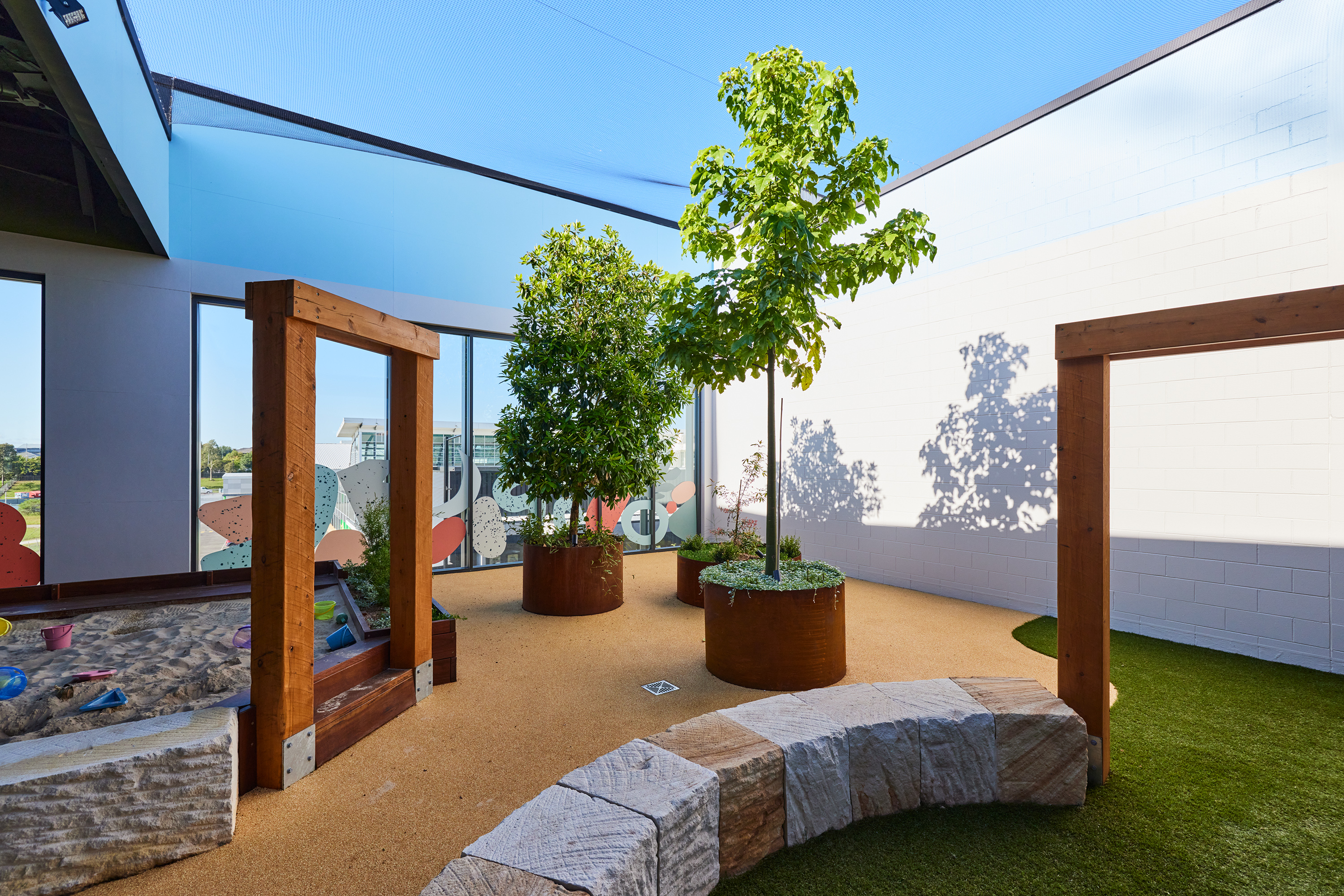 Synthetic turf area with climbing ramp, ride-on toys and slide