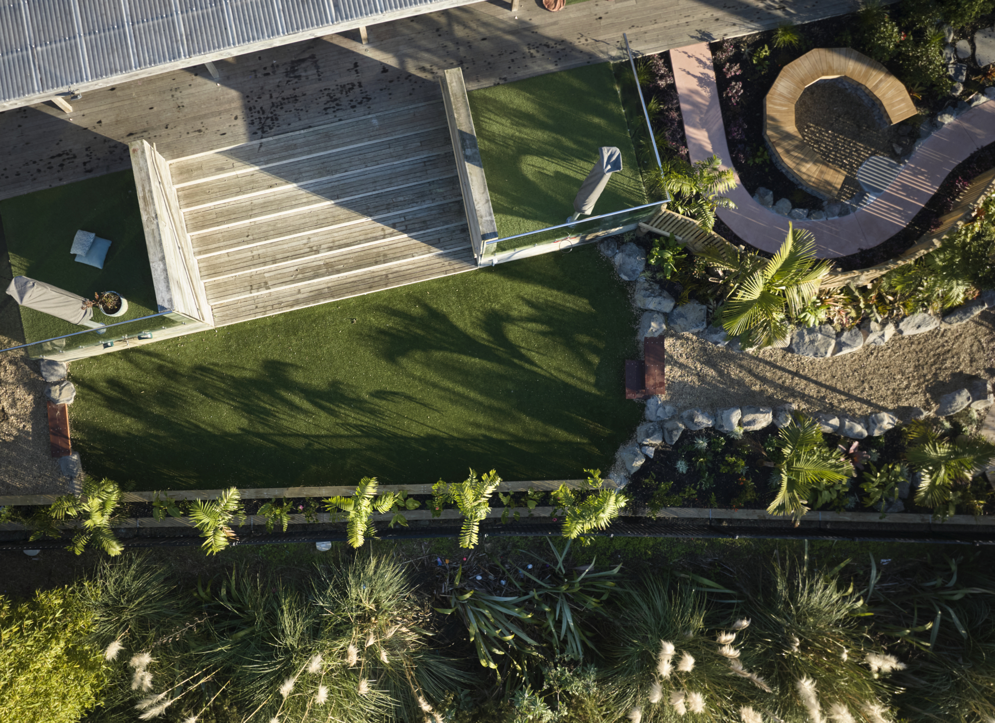 Aerial view of synthetic turf area with timber steps, circular seating bench and surrounding plantings