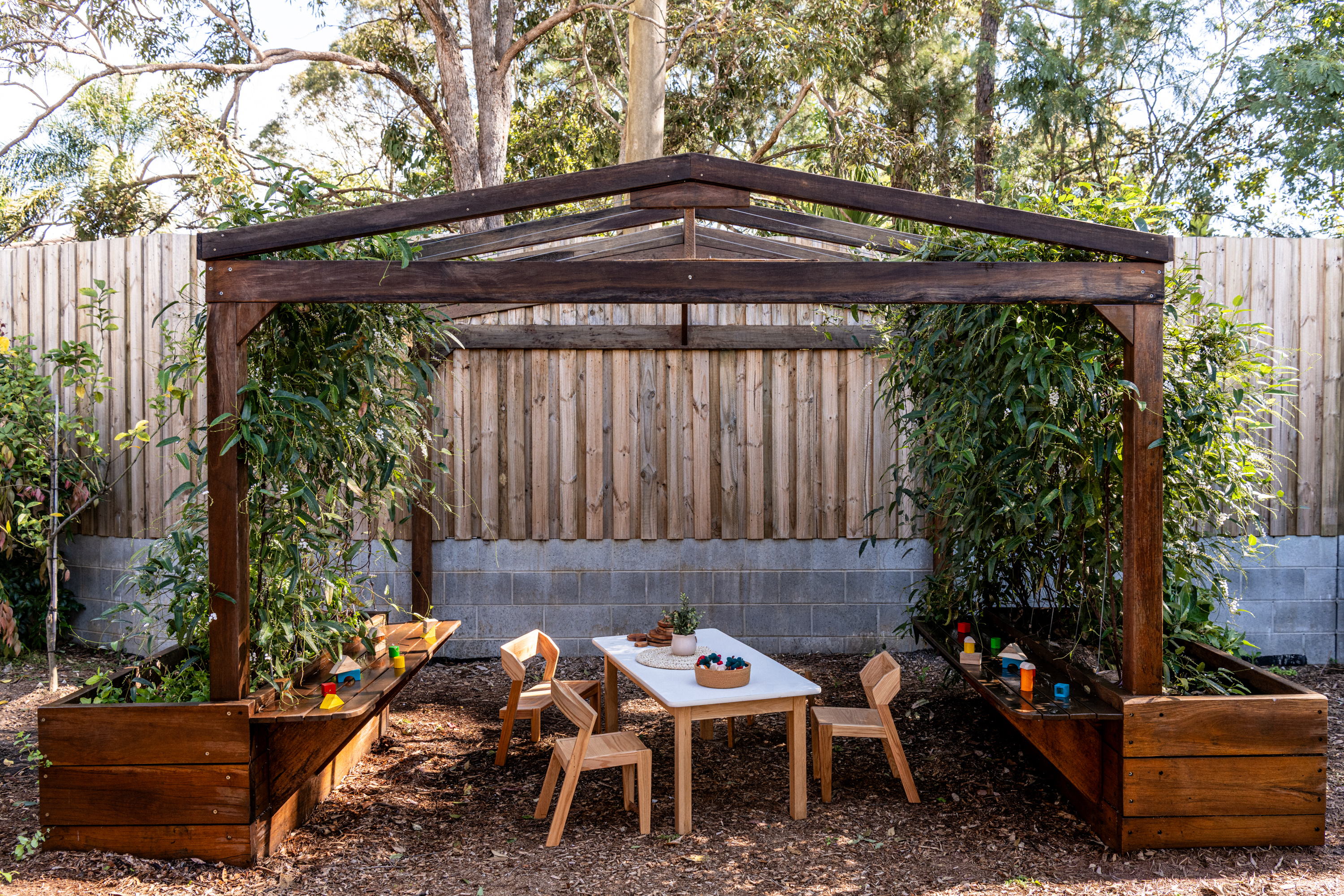 Timber post-and-beam pergola with garden beds