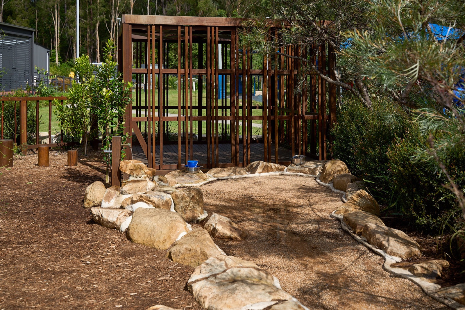 Rock-lined dry creek bed and sand play area