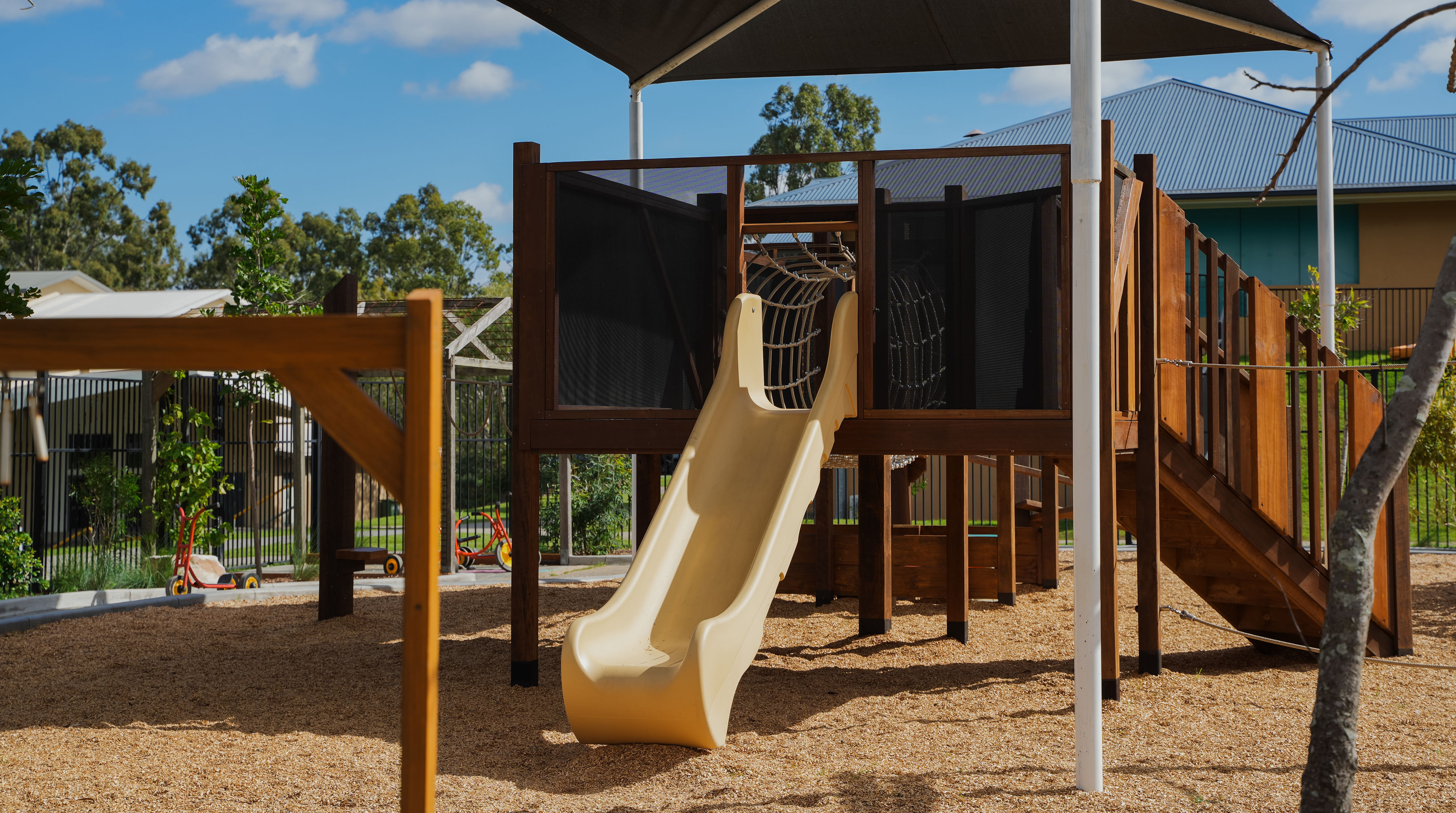 The multi-level play tower with slide and rope tunnel