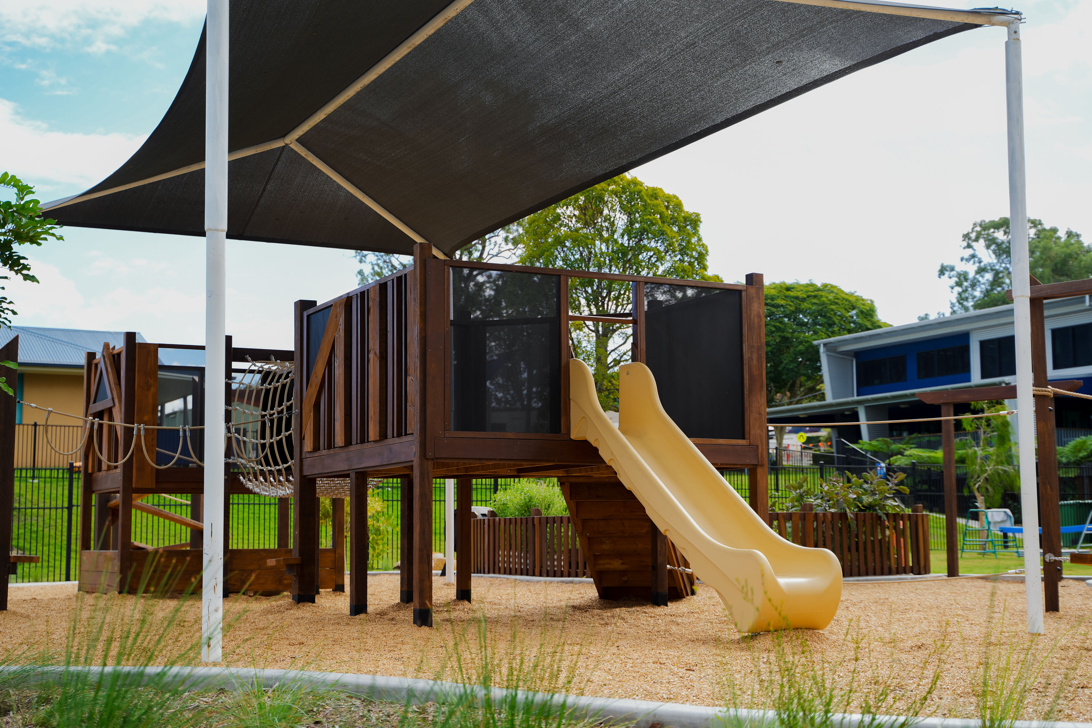 Play tower with slide and rope tunnel entrance