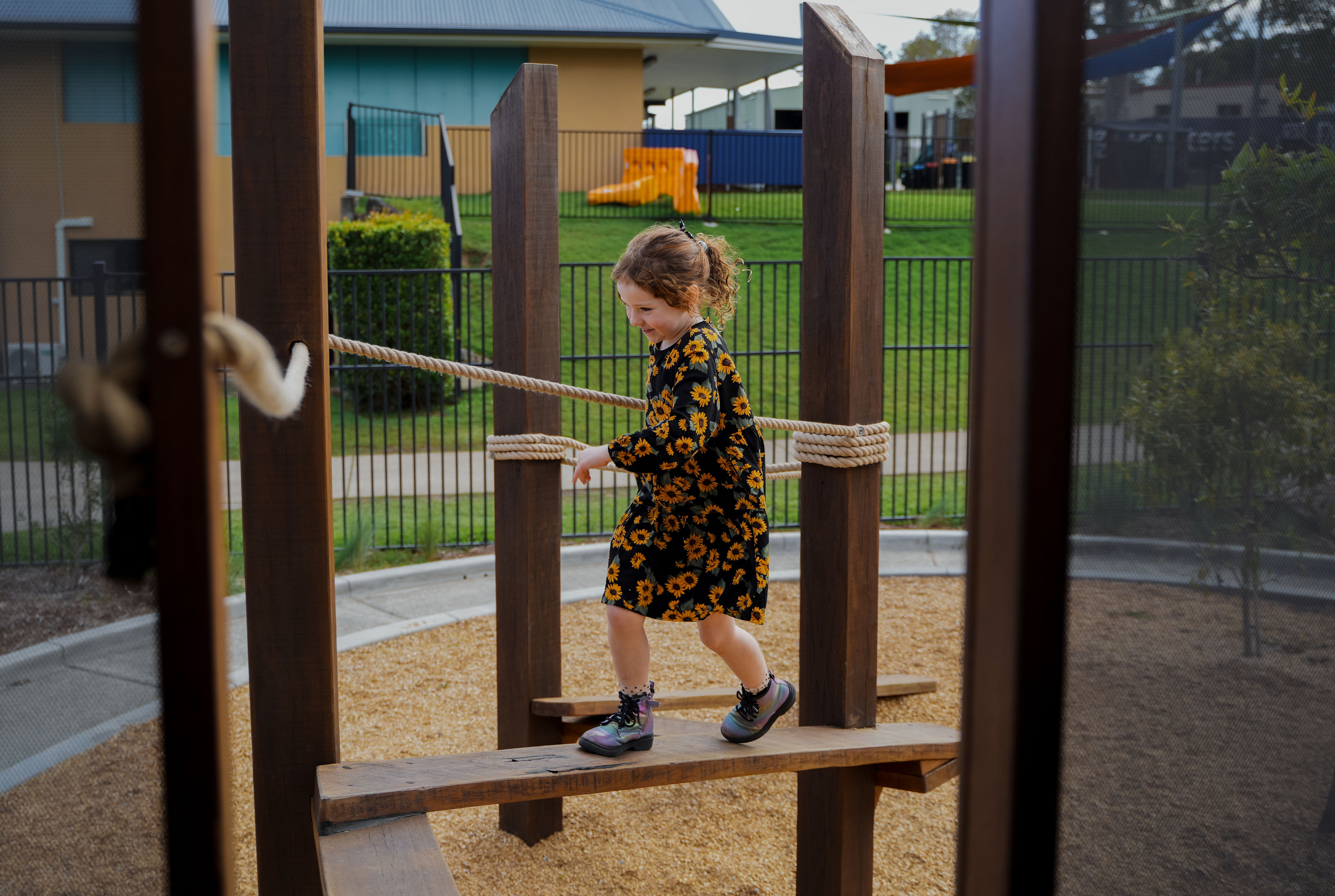 A child balancing across the timber balance beam trail