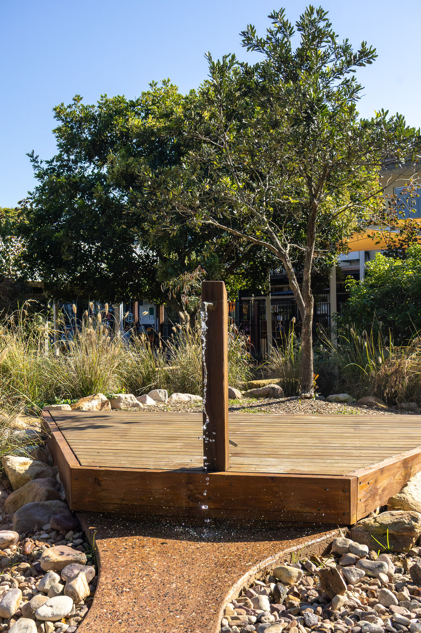 The wooden water tap feature dripping into the rock creek bed