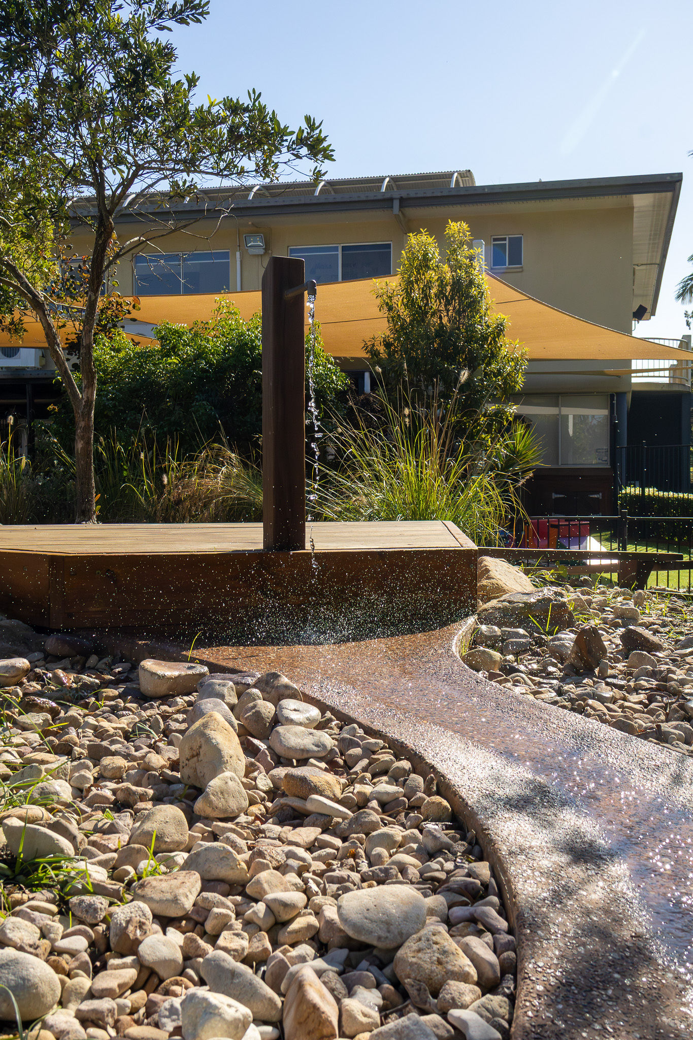 The water tap feature framed by the shade sails