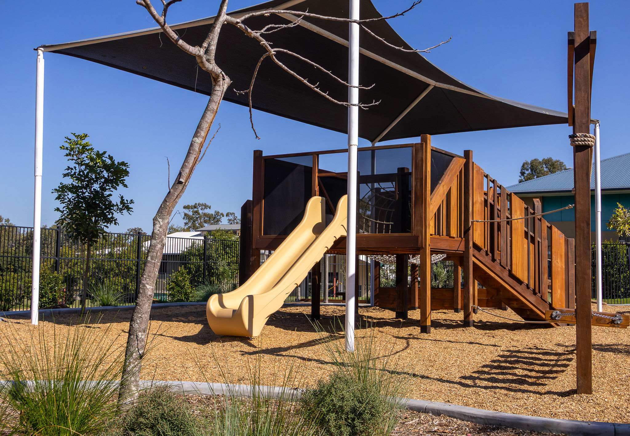 Wide view of the play tower with slide and rope net