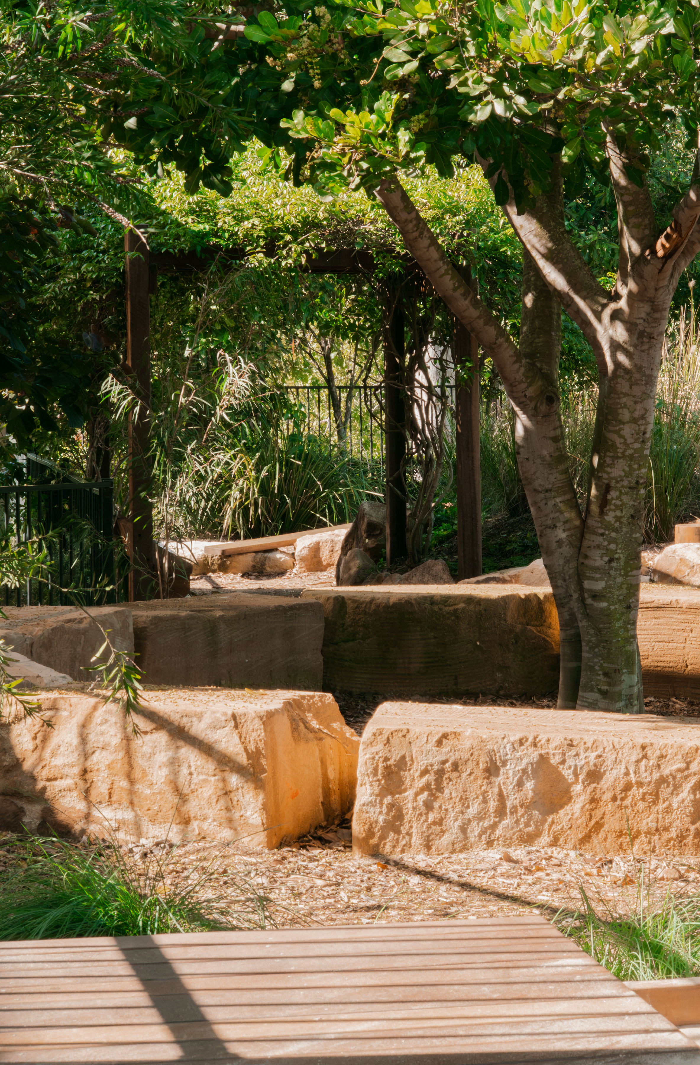 The sandstone boulder seating nook beneath the trees