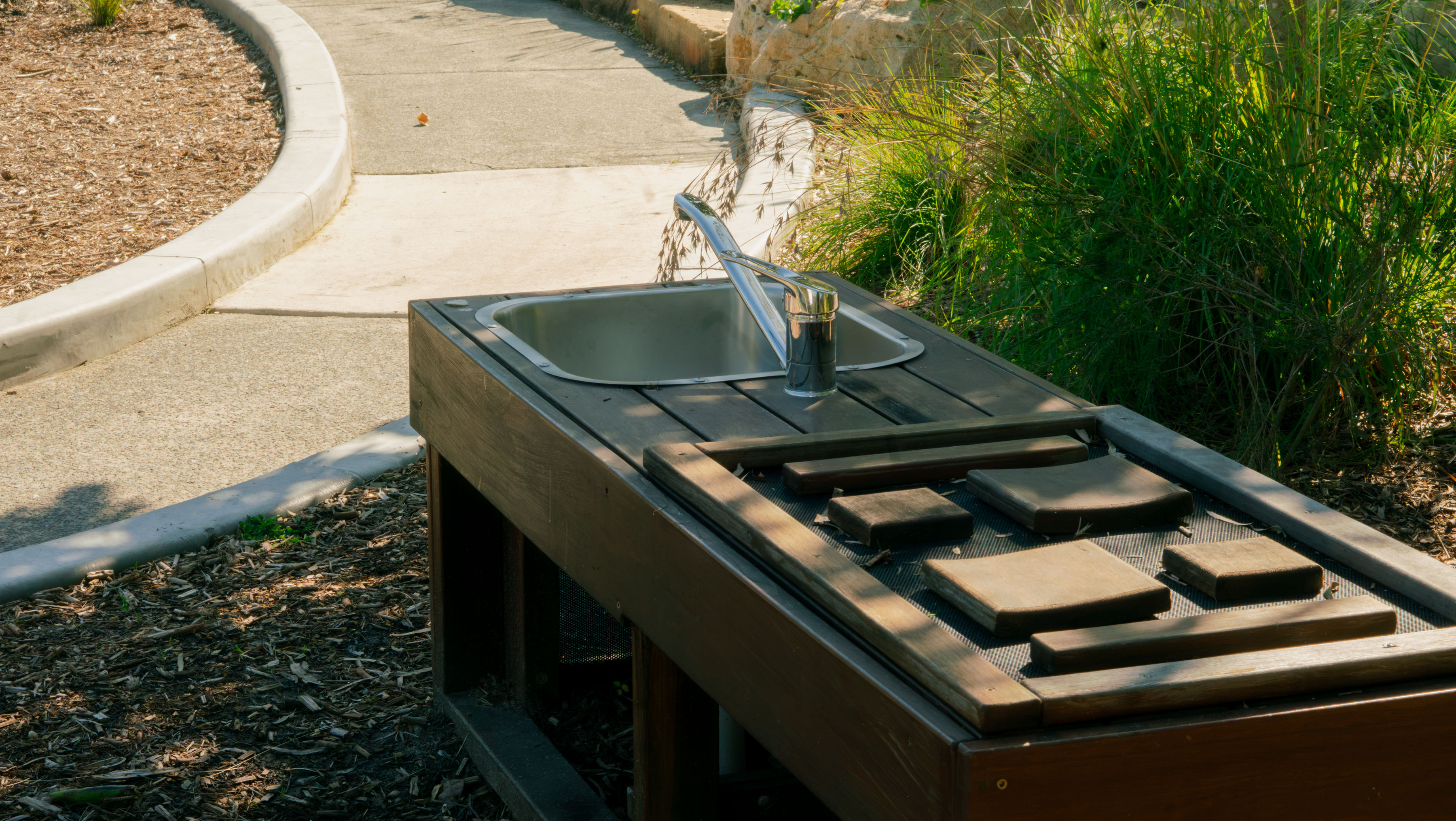 The mud kitchen sink and wooden play accessories