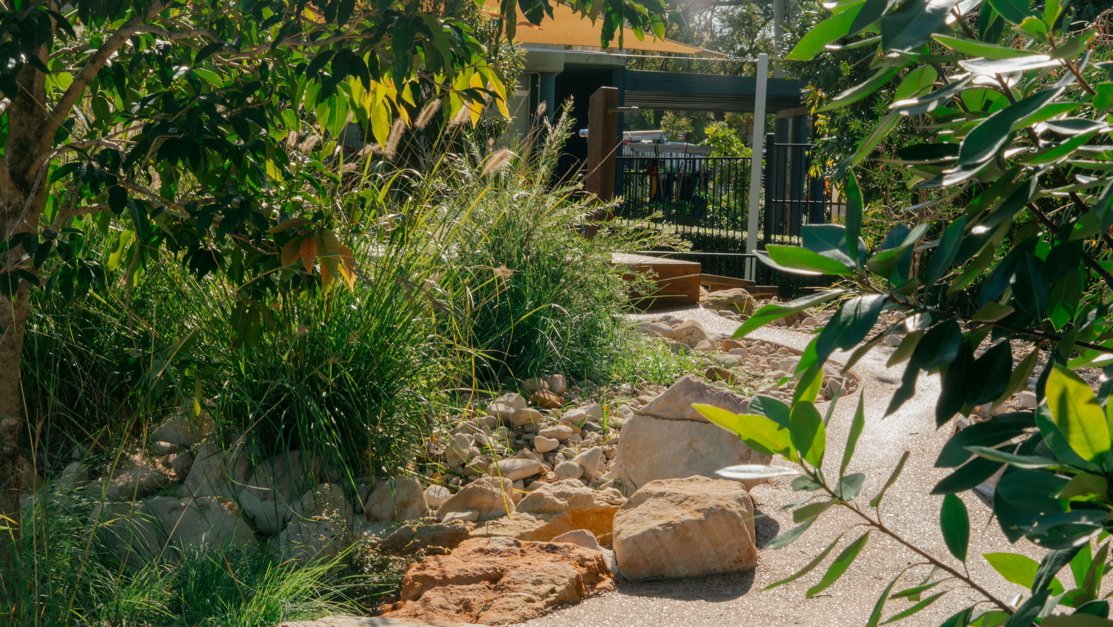 The dry creek bed pathway past the bee hotels