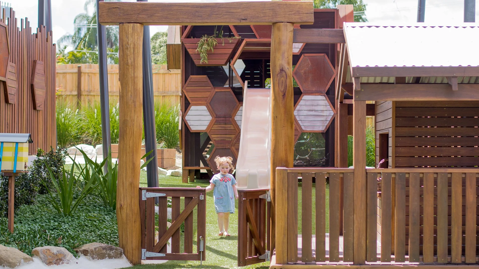 A child exploring a garden-rich natural play environment
